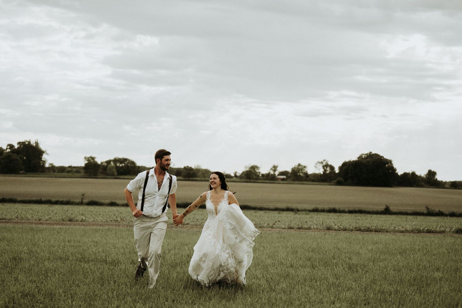 couple running during sunset in wedding outfits.