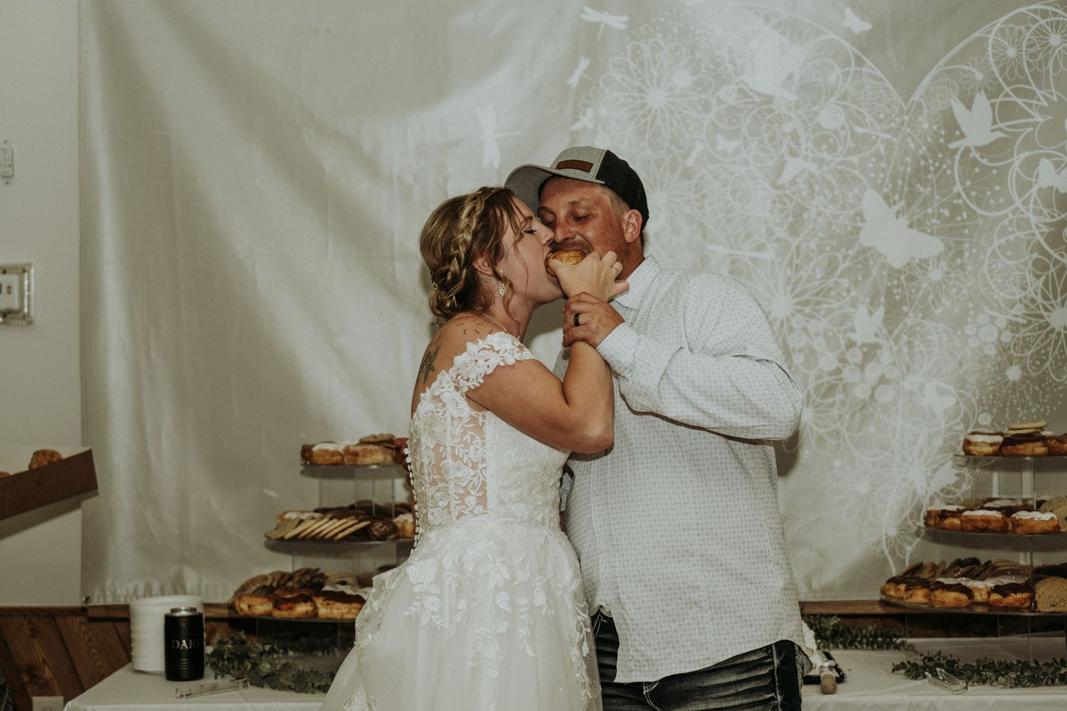 bride and groom at their reception enjoying their cake together as newlyweds.