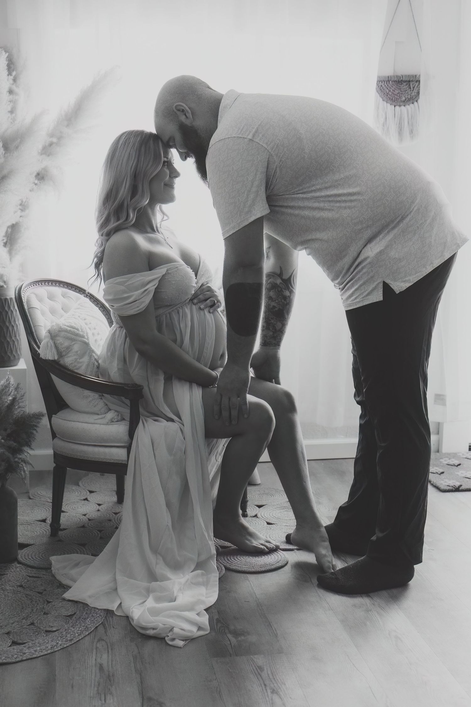 A black and white photo series showing a family in casual attire posing together on a wooden floor.