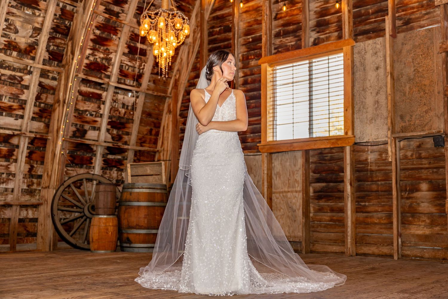 Rustic barn interior with wooden beams and warm lighting creates romantic wedding ambiance.