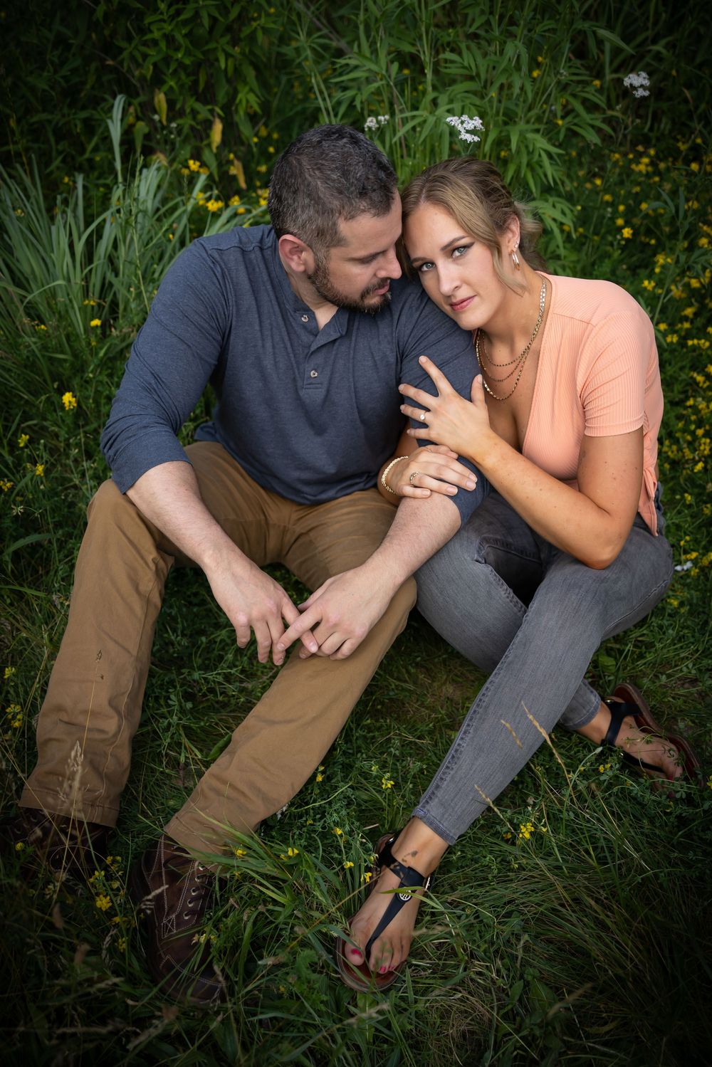 Intimate couple portrait session in tall grass with natural lighting.