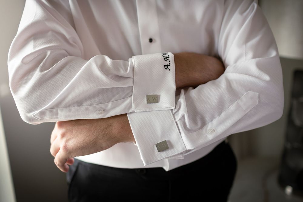 Close-up shots of formal white dress shirt and cufflinks during wedding preparation.