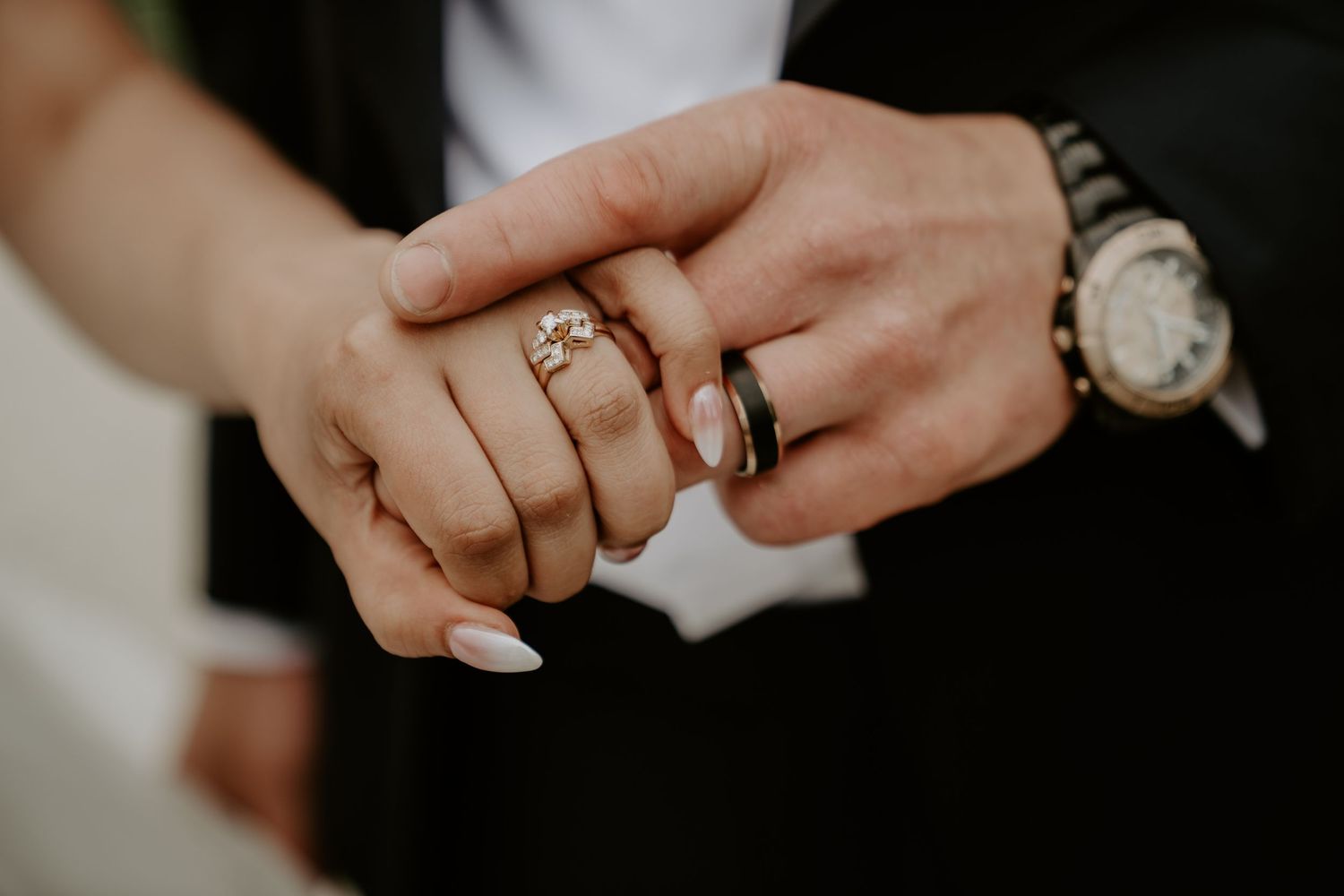 close up of bride and groom hands with rings