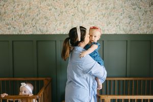 A series of four photos showing tender moments between parent and baby in a nursery room with green walls.