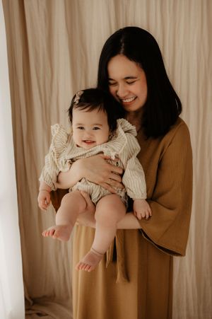 Tender moment captured between parent and baby in warm neutral tones during portrait session.
