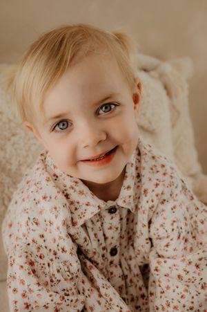 Close-up portrait shots in soft lighting capturing sweet expressions and bright blue eyes.