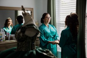 Mom and daughther chat near a mirror and dress form while preparing for a quinceanñera ceremony. Charleston, Summerville,South Carolina