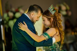 Intimate dance, woman wearing green embroidered gown and jeweled tiara at a formal celebration. Charleston, Summerville,South Carolina