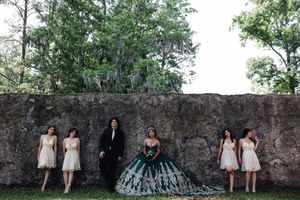 A series of quinceanera party portraits captured against a rustic stone wall in an outdoor garden setting.