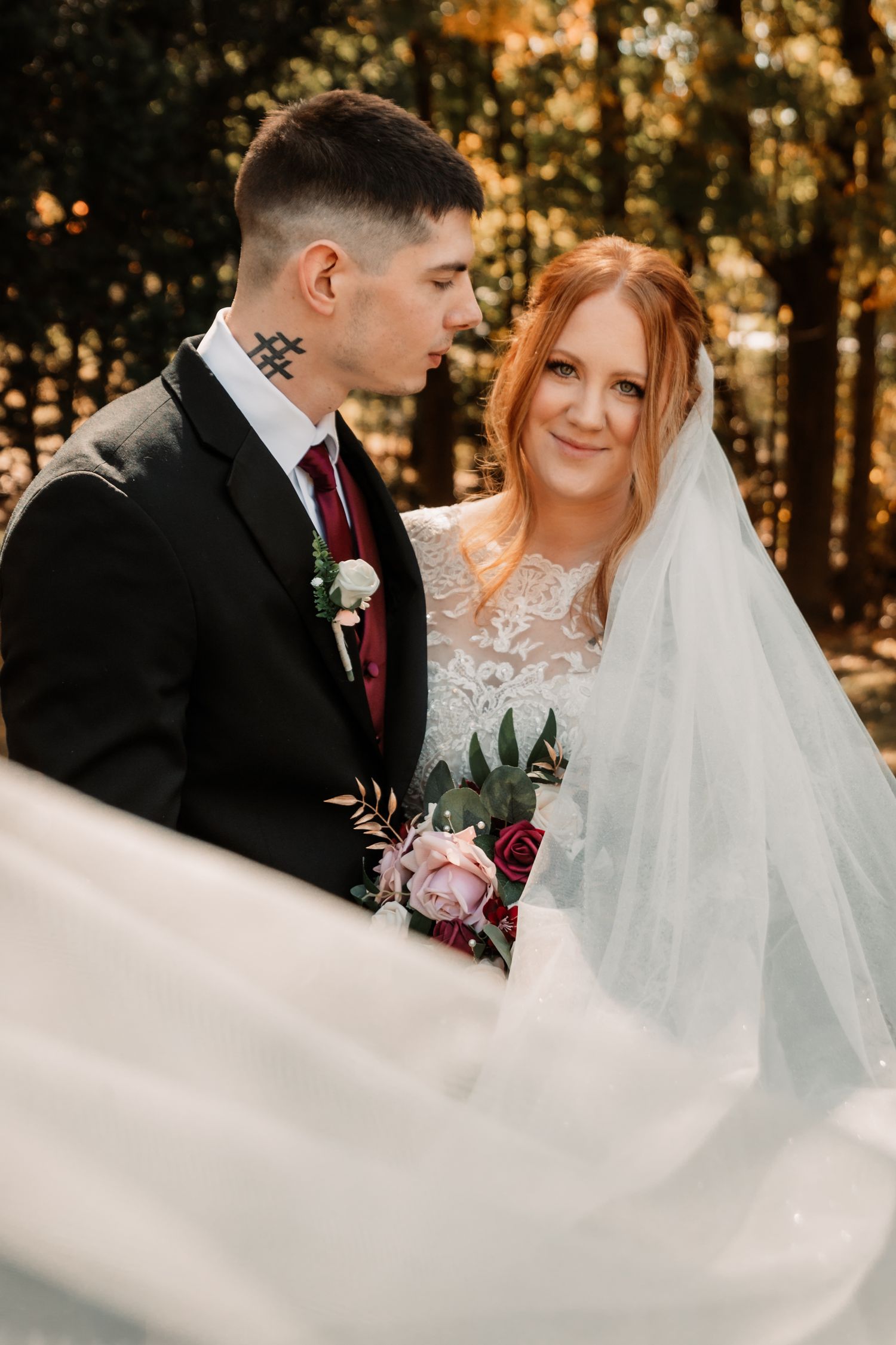 A bride and groom share an intimate moment during their autumn forest wedding.