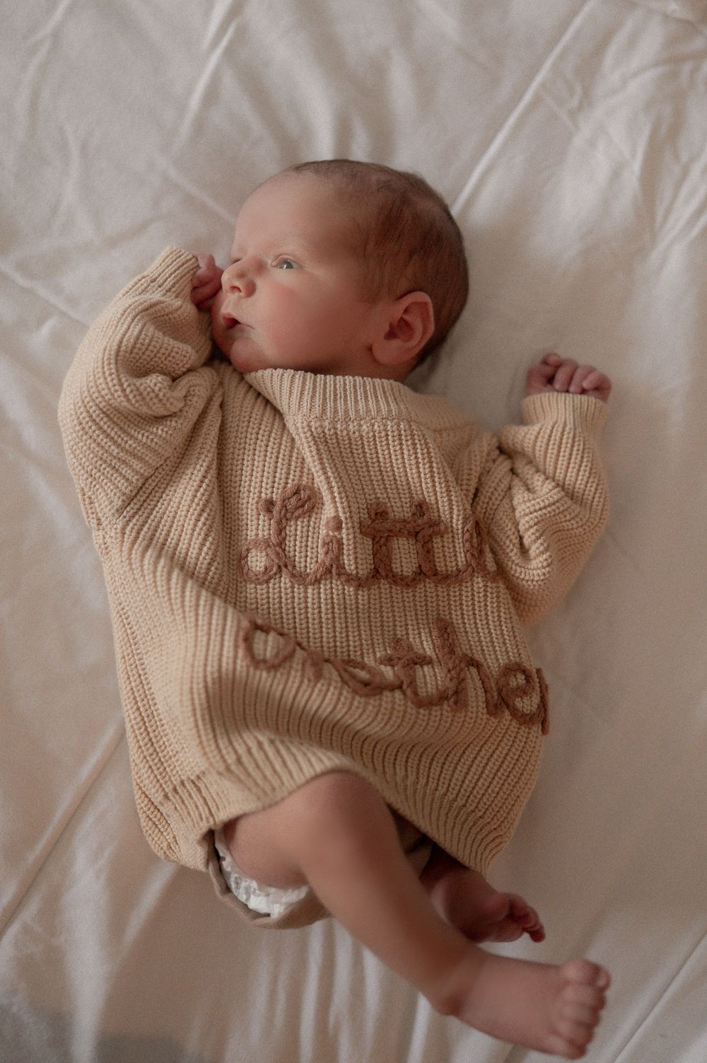 Newborn baby laying calmly in soft natural light