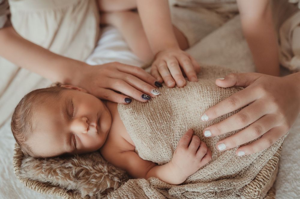 Newborn sleeping with family members surrounding in love and touch