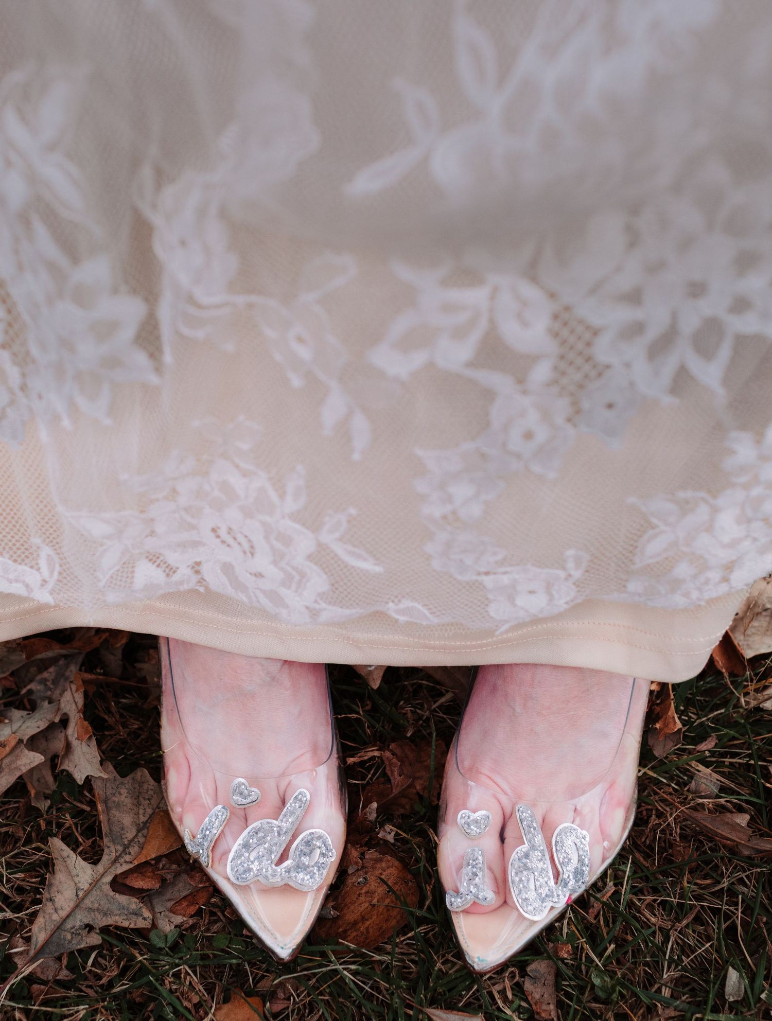 Bride wearing elegant lace wedding gown shows off sparkling crystal embellished pointed-toe heels.