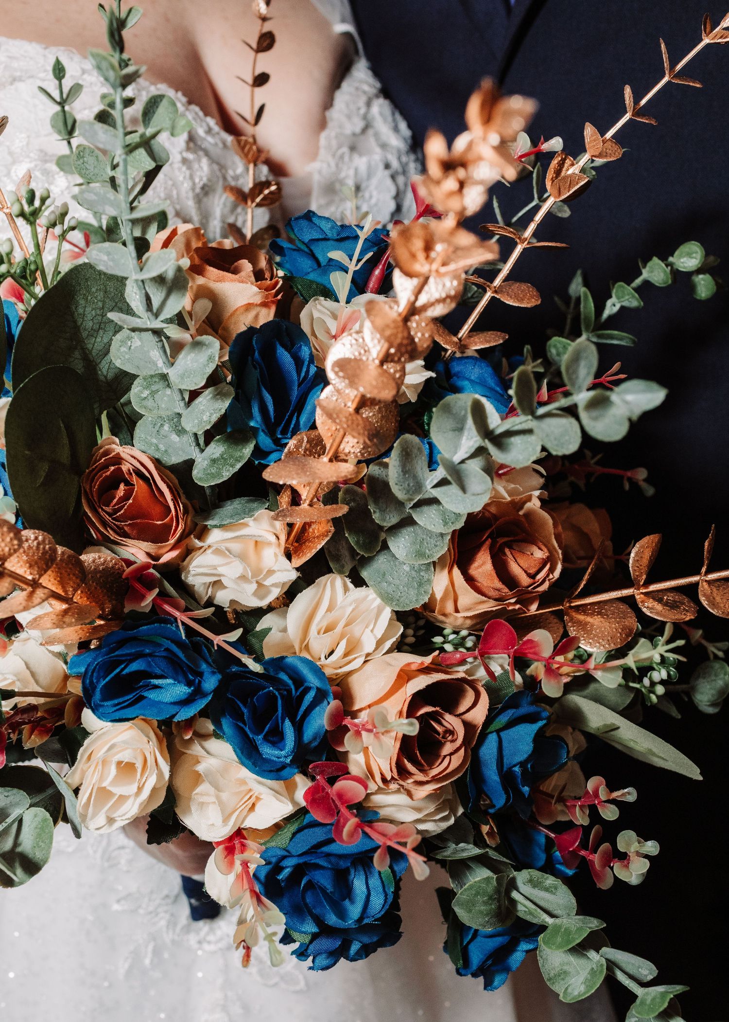 Bridal bouquet with blue, copper, and cream roses with eucalyptus greenery.