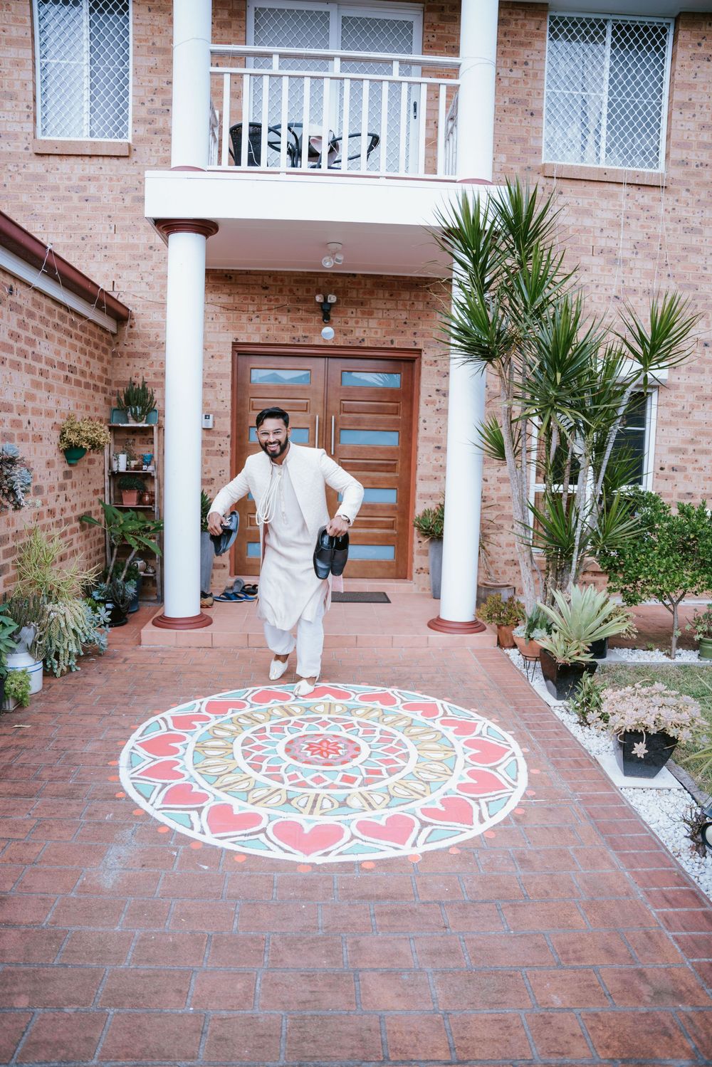 Groom arriving at the Nikah venue past a colourful rangoli in Sydney