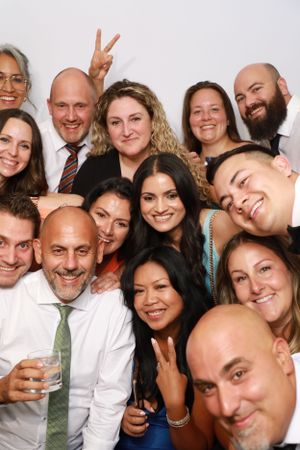 Large group of wedding guests crowding together for a fun photo booth picture.