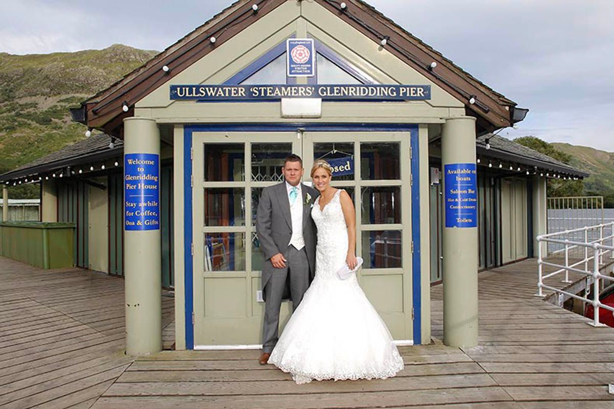 Bride and groom posing at Ullswater Steamers Glenridding Pier on their wedding day.