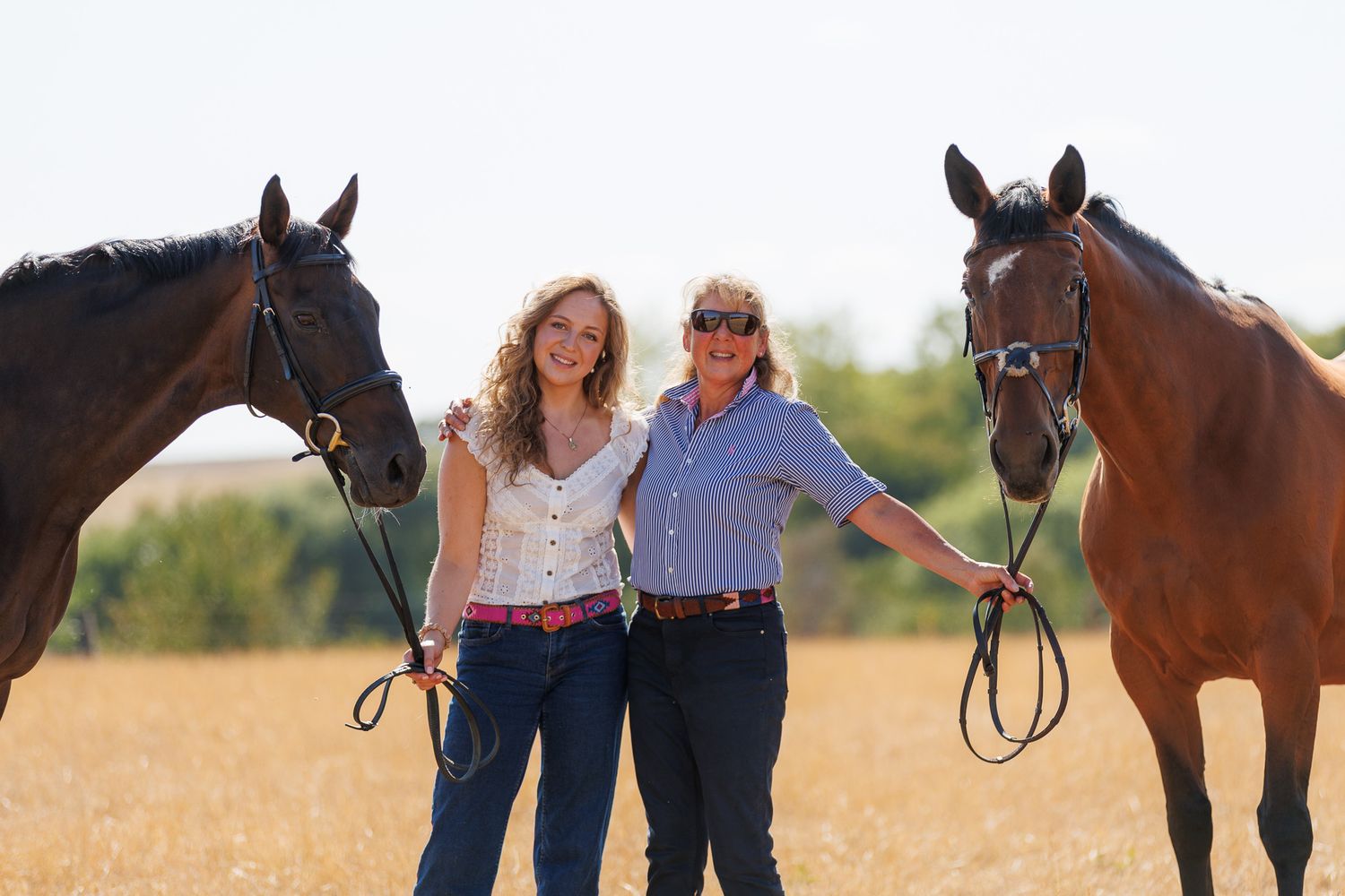 A horse and its rider enjoy an outdoor photoshoot session near rustic wooden fencing on a sunny day.