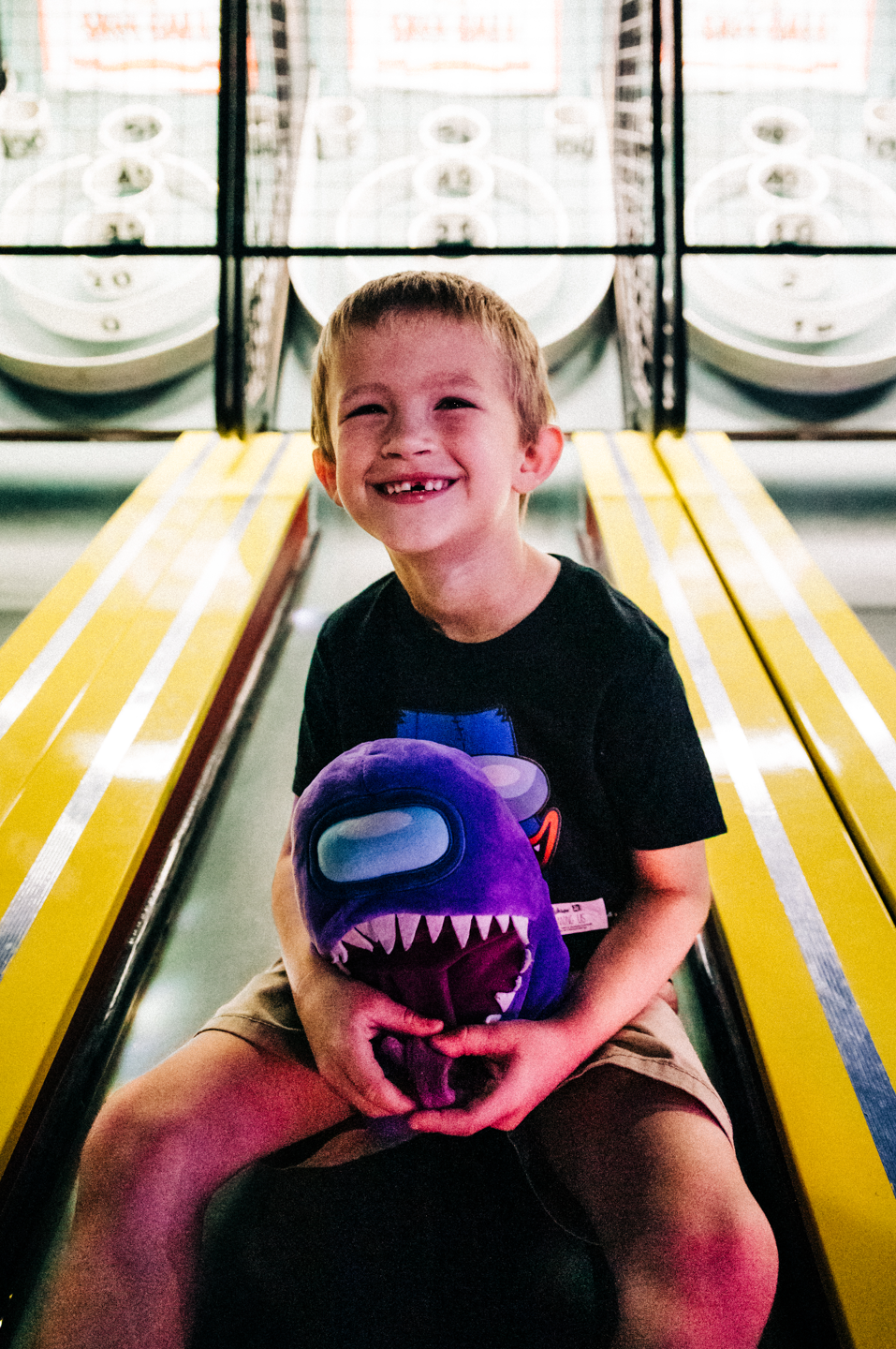 Candid birthday portrait of a boy holding his arcade prize at Fun Depot in Lake Worth Beach.