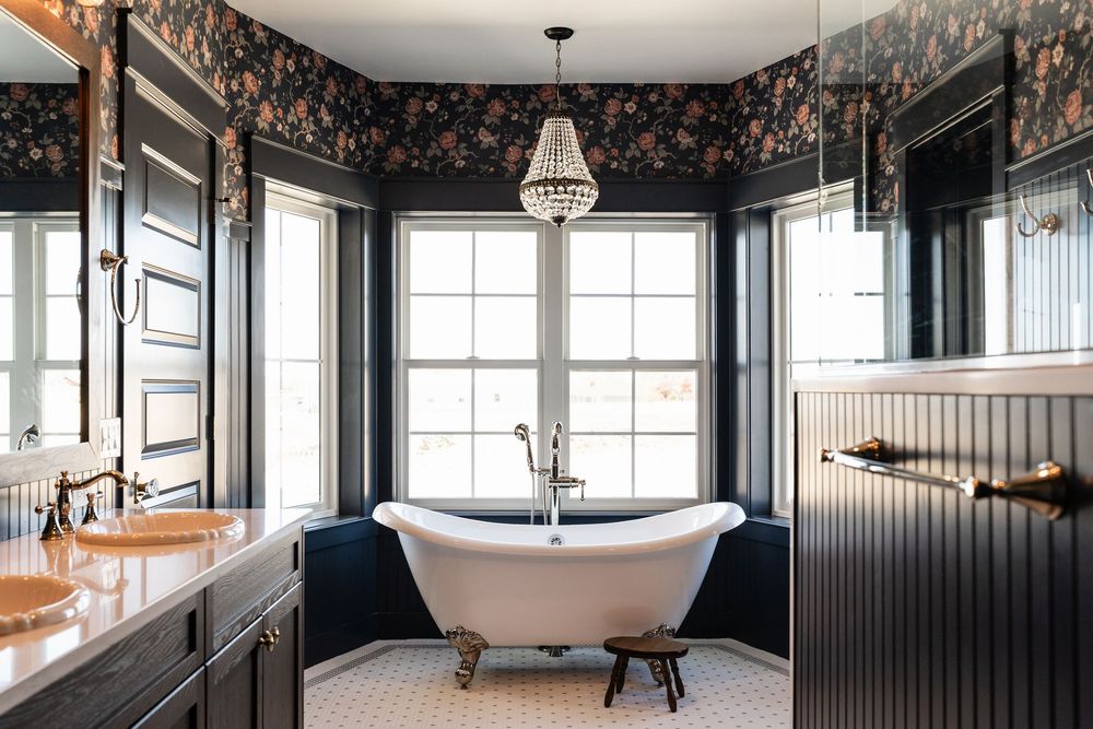 wide view of bathroom with clawfoot tub and dark walls with wallpaper