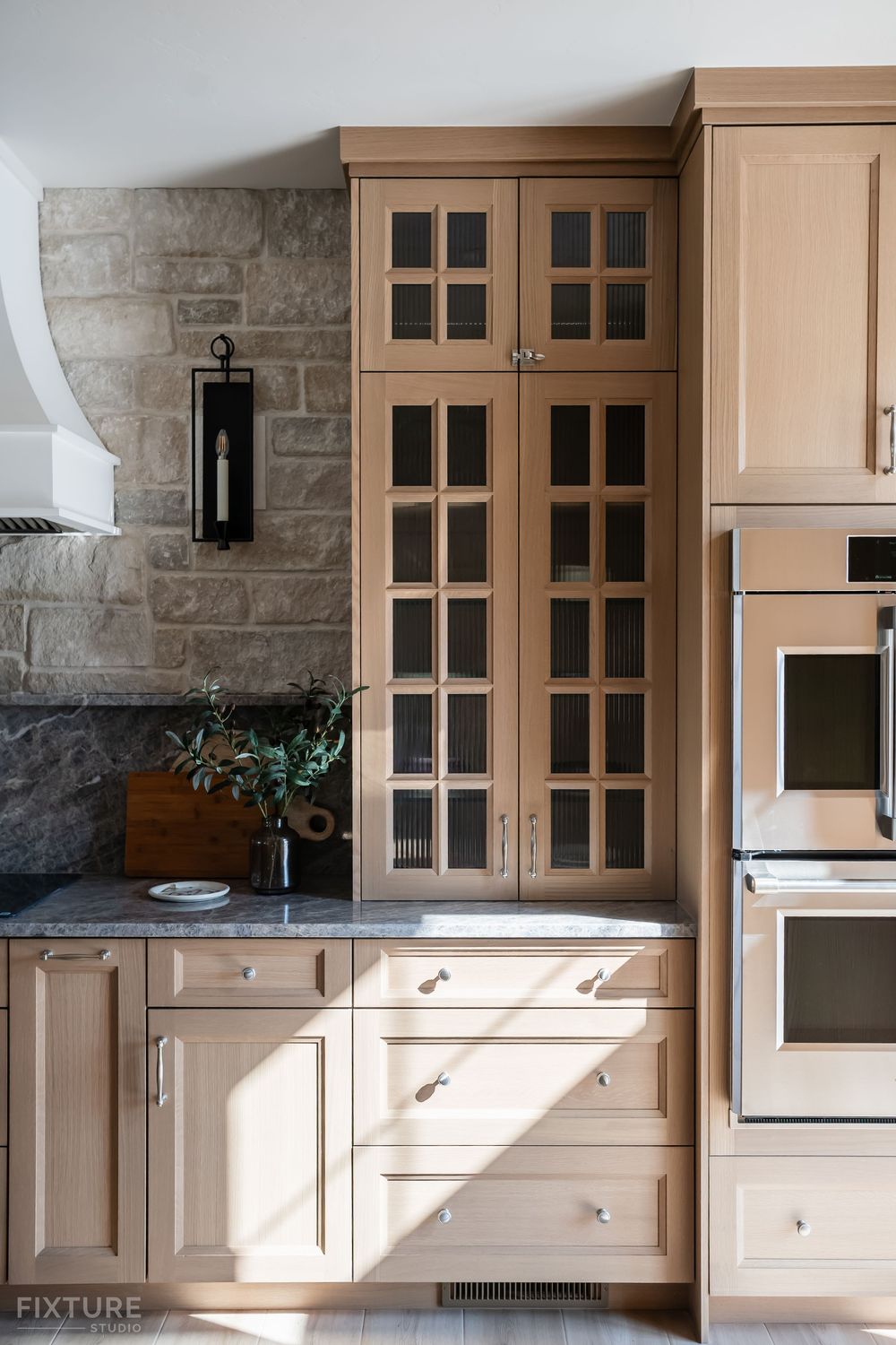 vertical photo of sun shining on kitchen cabinets