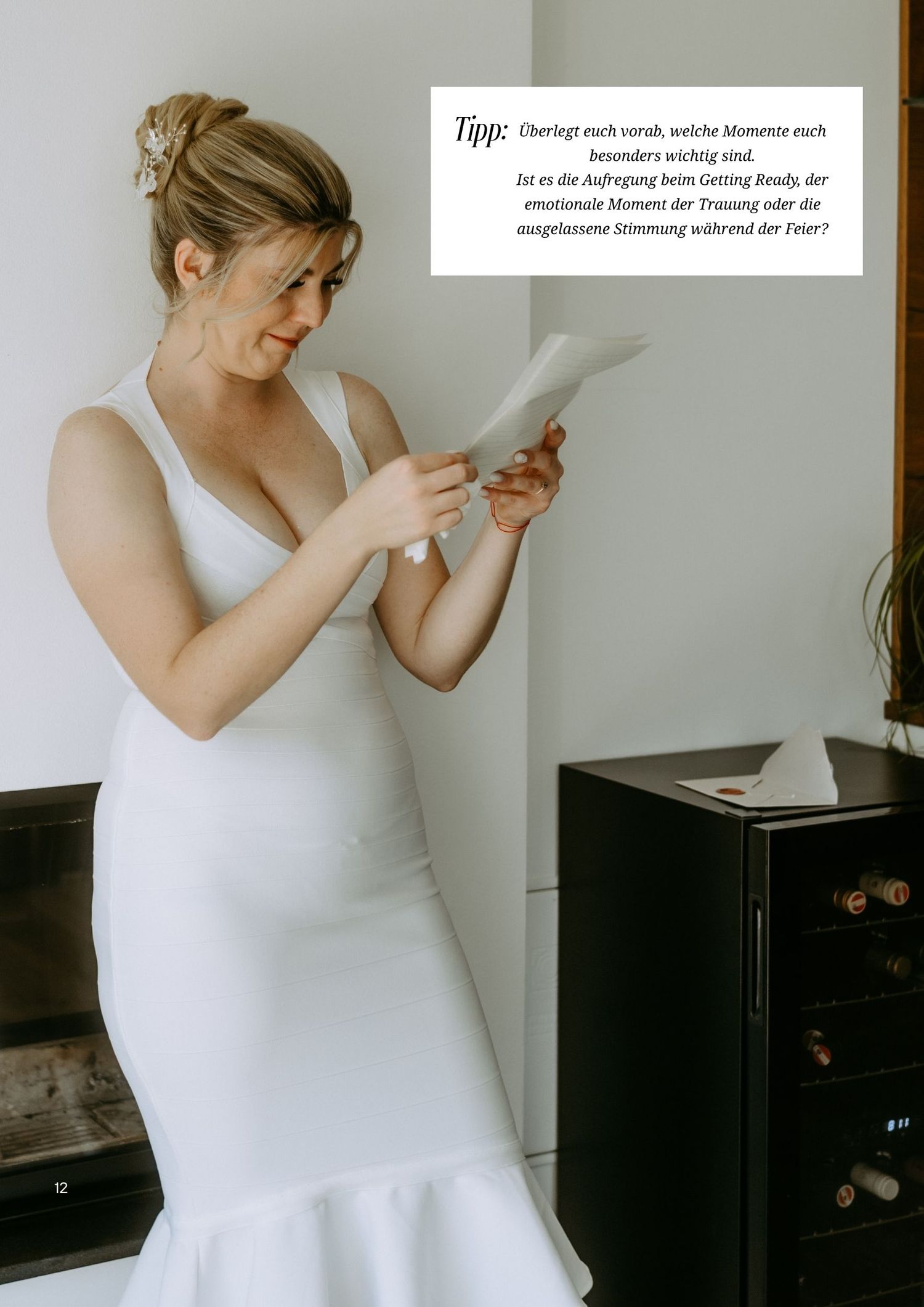 Bride in white mermaid gown reading a letter before her wedding ceremony, standing by a fireplace.