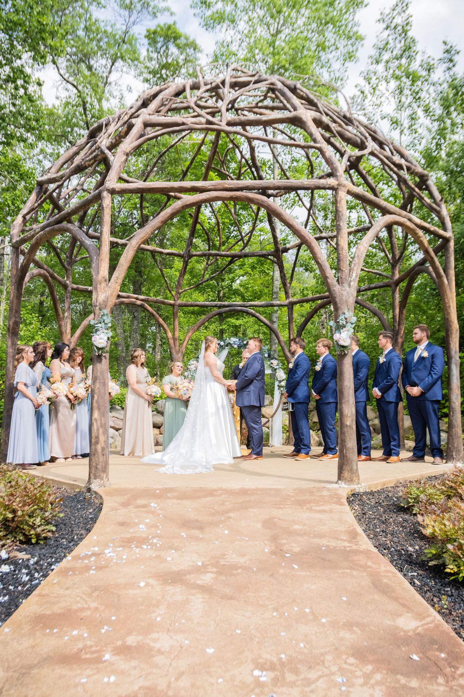 A joyful bride and groom share a romantic nose-to-nose moment under a flowing white veil on their wedding day.