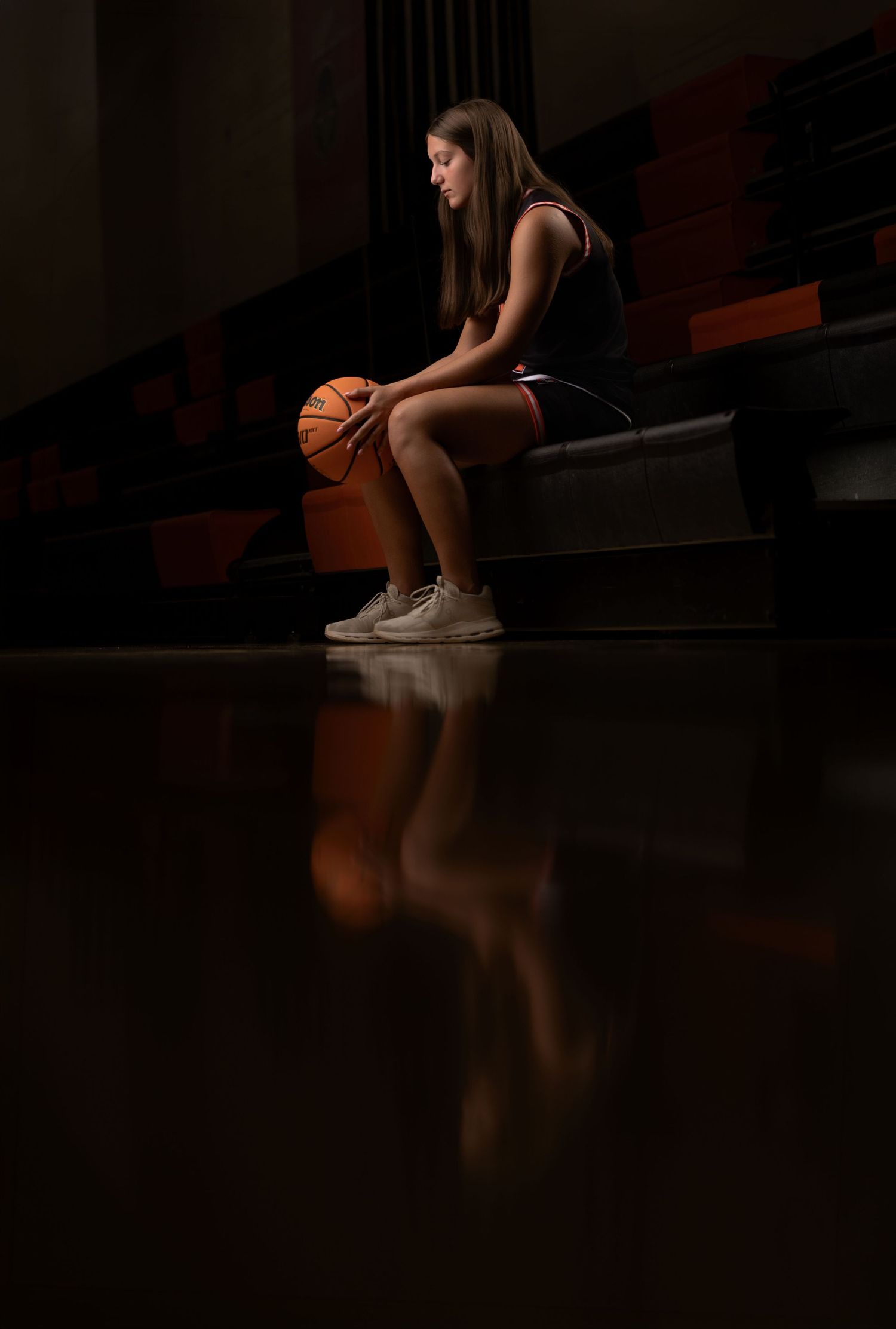 Moody senior portrait photographed with dramatic light and shadow