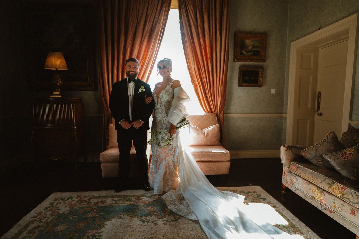 Wedding couple beside the curtains and window in a historic Tankardstown House interior.