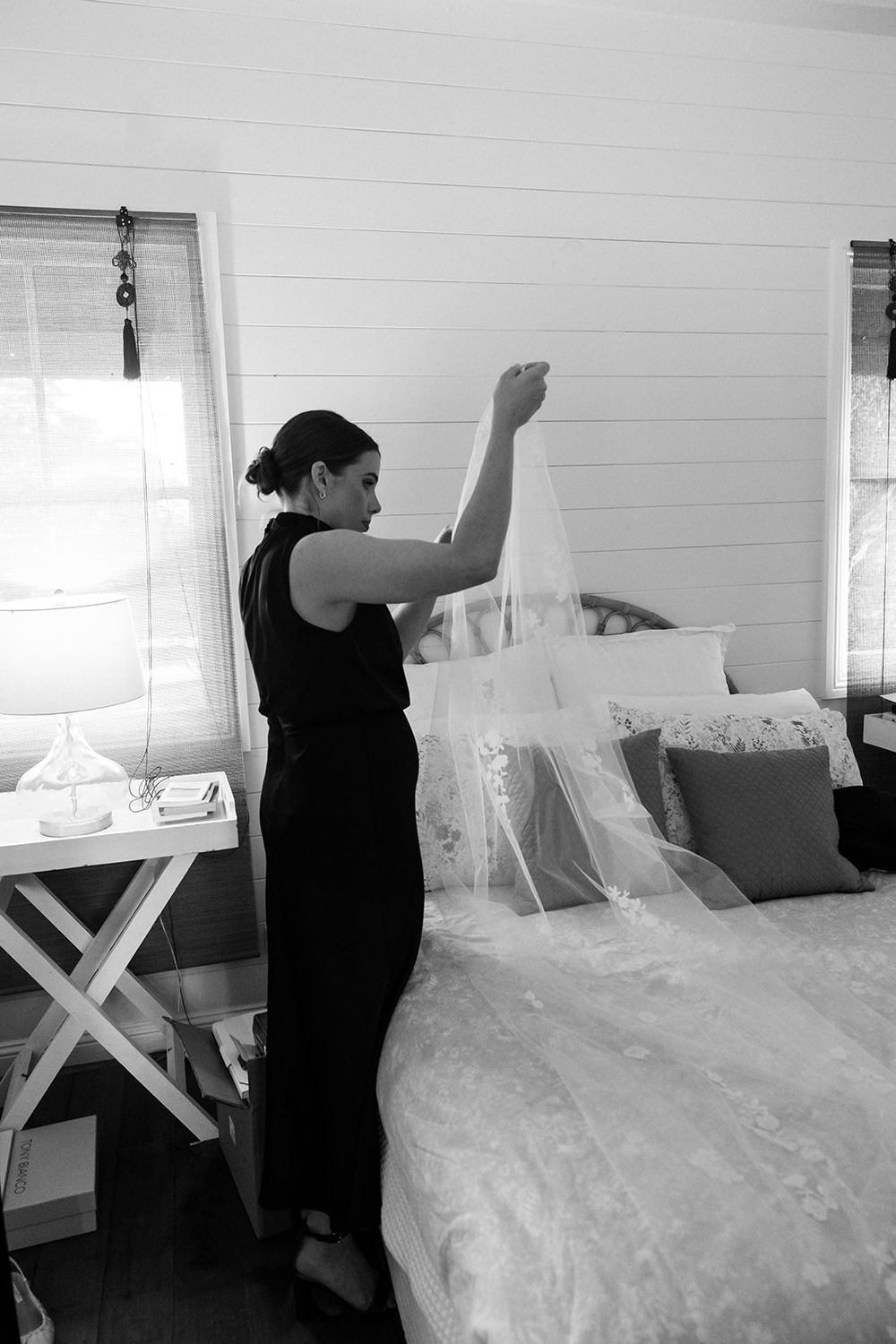 A sequence showing someone smoothing out white bedding in a sunlit bedroom.