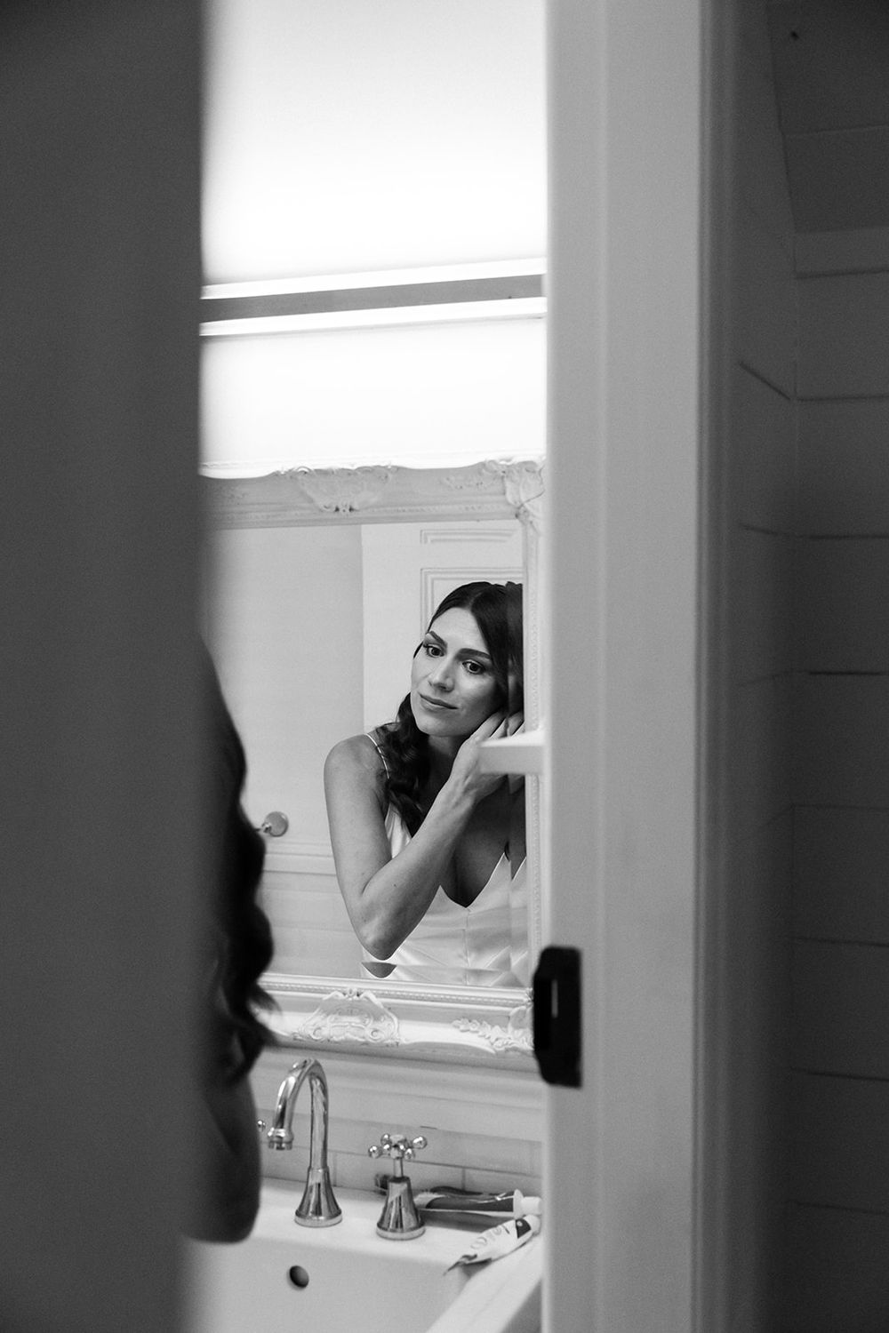 Artistic black and white photograph showing reflections in a bathroom mirror.