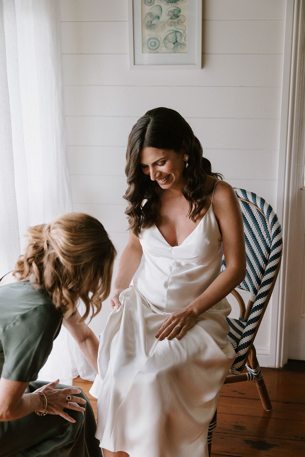 Candid moments of preparation in a bright white room with wooden floors and soft decor.