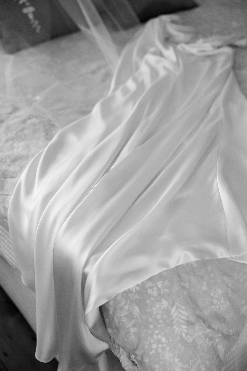 Close-up shots of white flowing wedding dress fabric with delicate lace details.