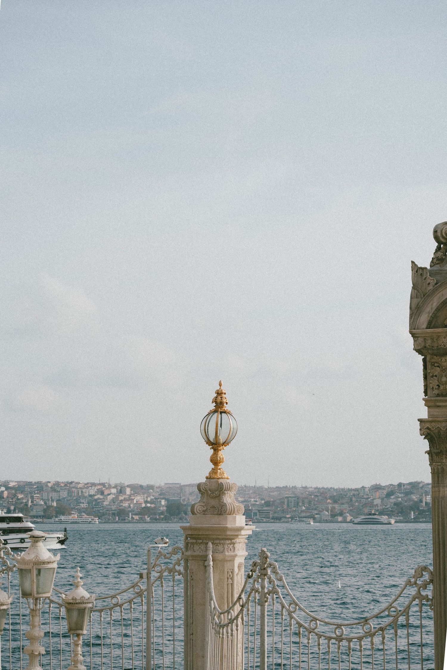 Finial ornemental doré sur poteau en marbre près du détroit du Bosphore à Istanbul, en Turquie, avec la ligne d'horizon de la ville en arriè