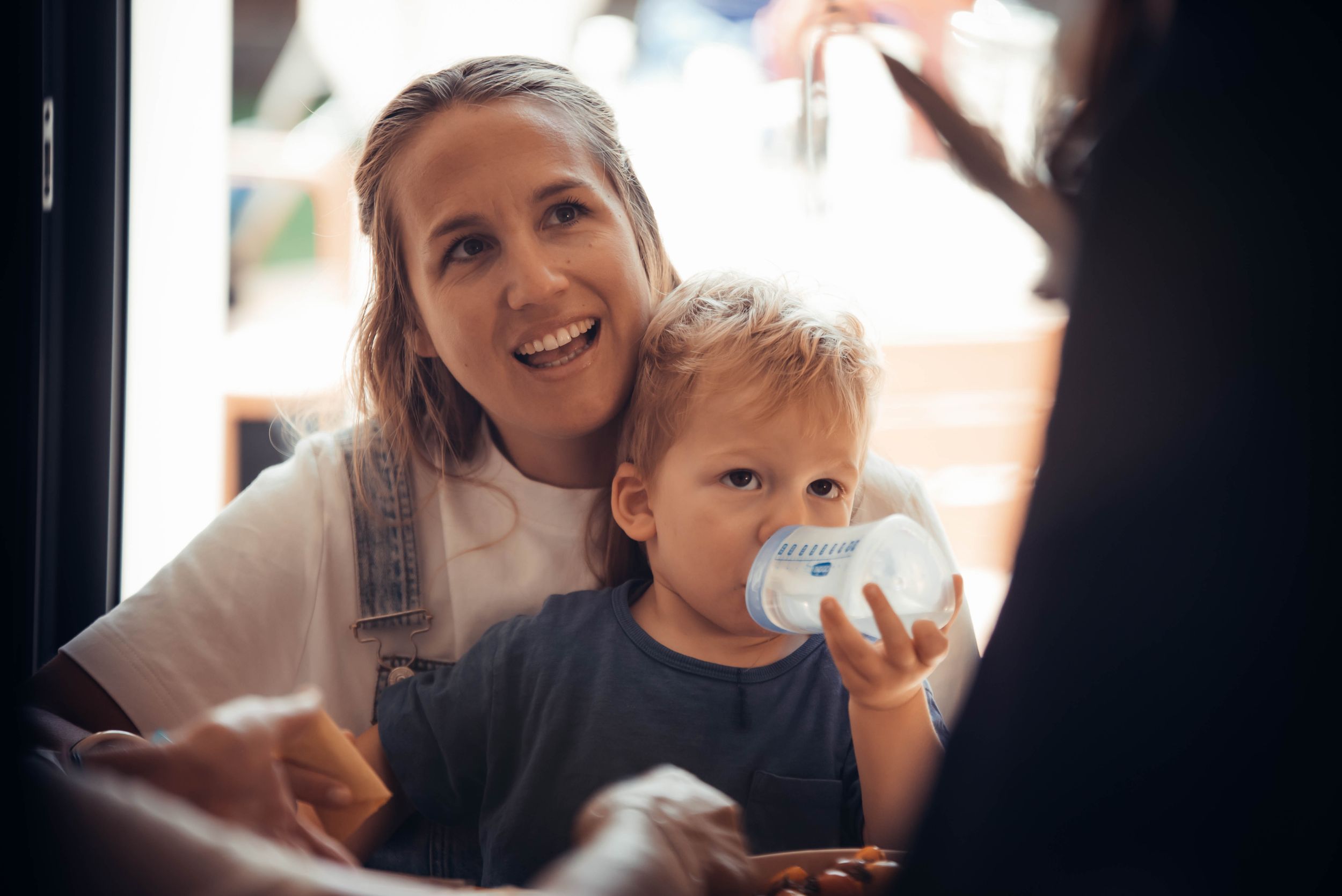 Mère souriante partageant un moment complice avec son jeune enfant