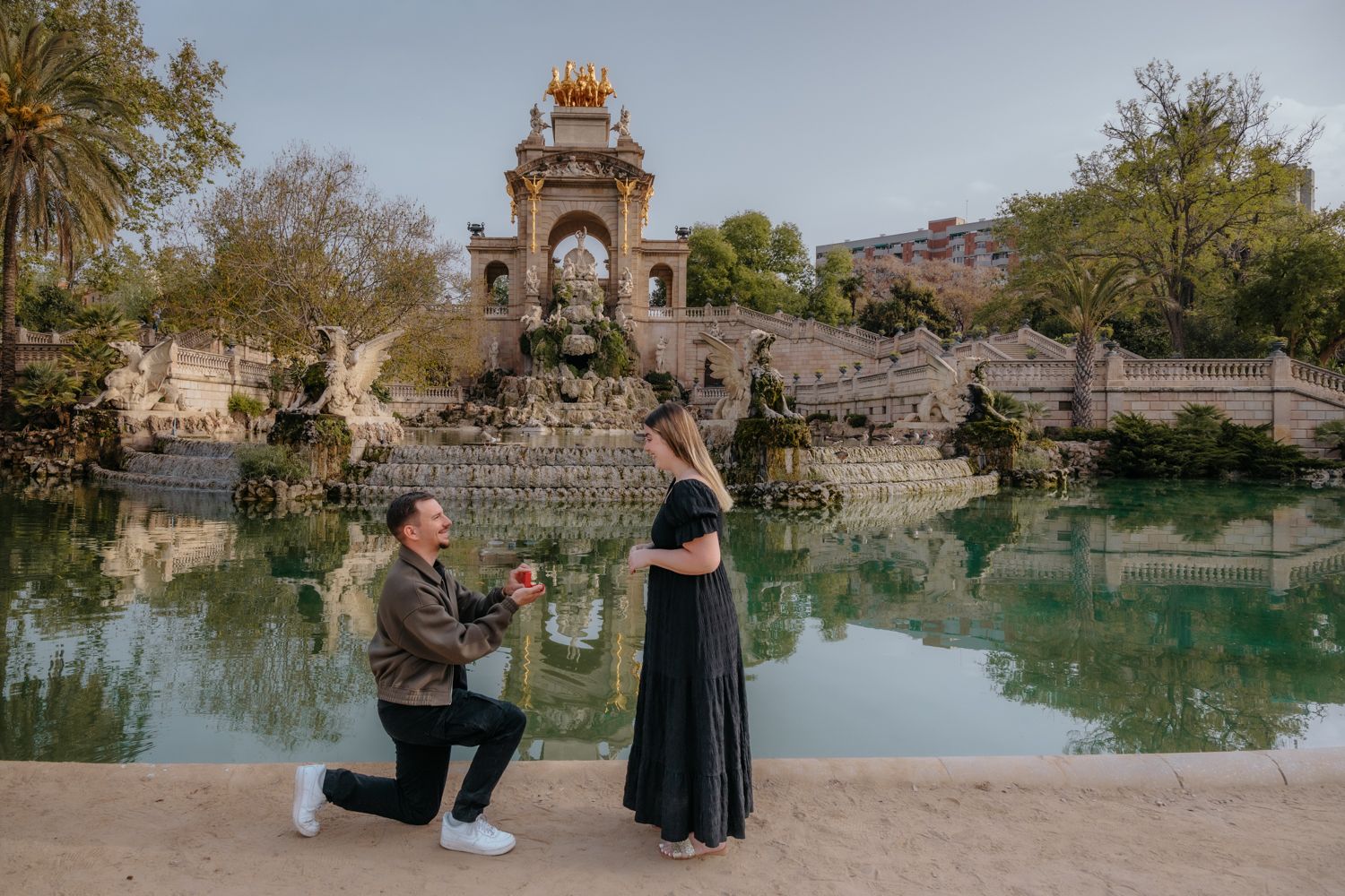 A surprise engagement photoshoot on the grand, sweeping stone staircase of the Cascada Monumental in Ciutadella Park, Barcelona.