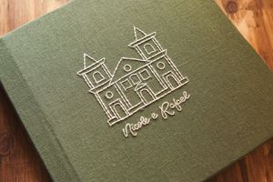 Green linen wedding photo album embossed with a church illustration and names Nicole & Rafael.