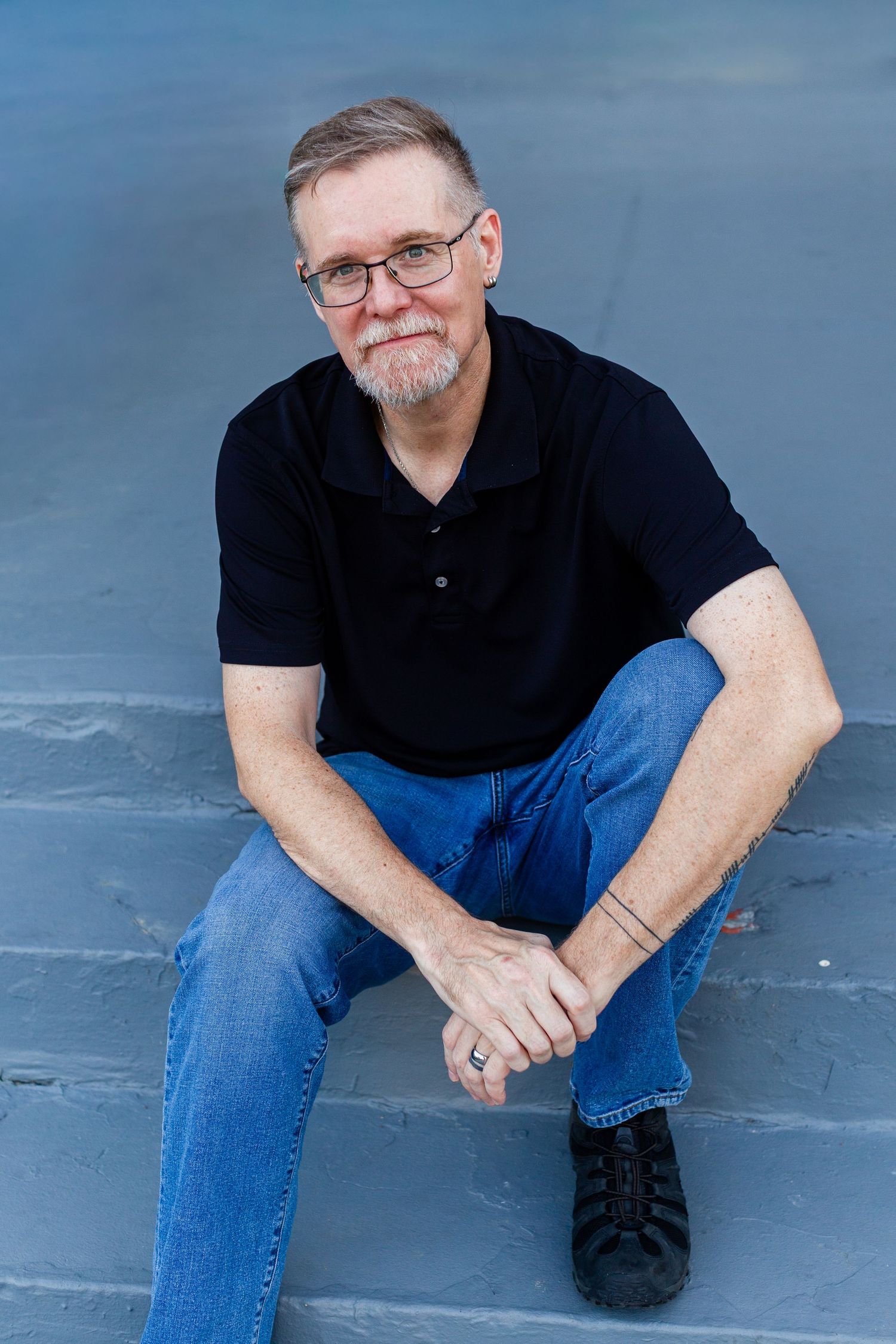Headshot of a man sitting on gray concrete steps. Guaynabo, Puerto Rico.
