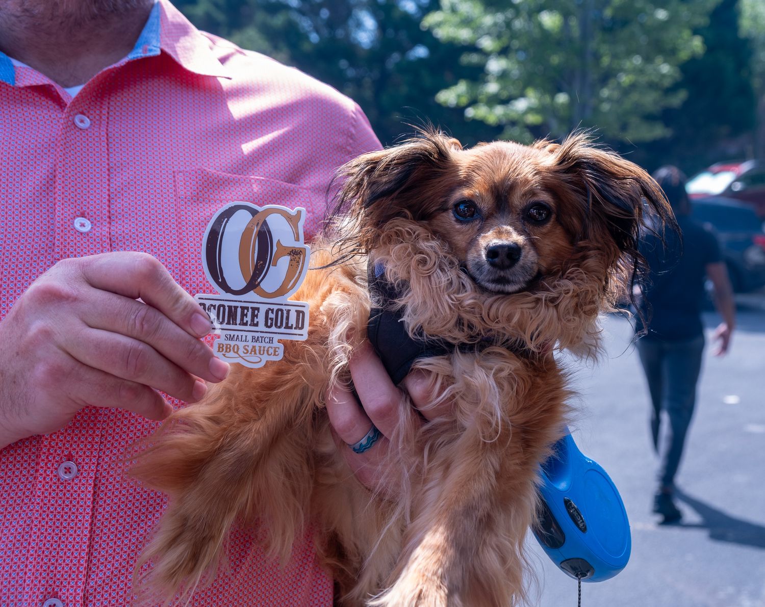 Picture of a dog and a person holding a logo for a business that hired Nichole Meshad Photography to photograph their event.