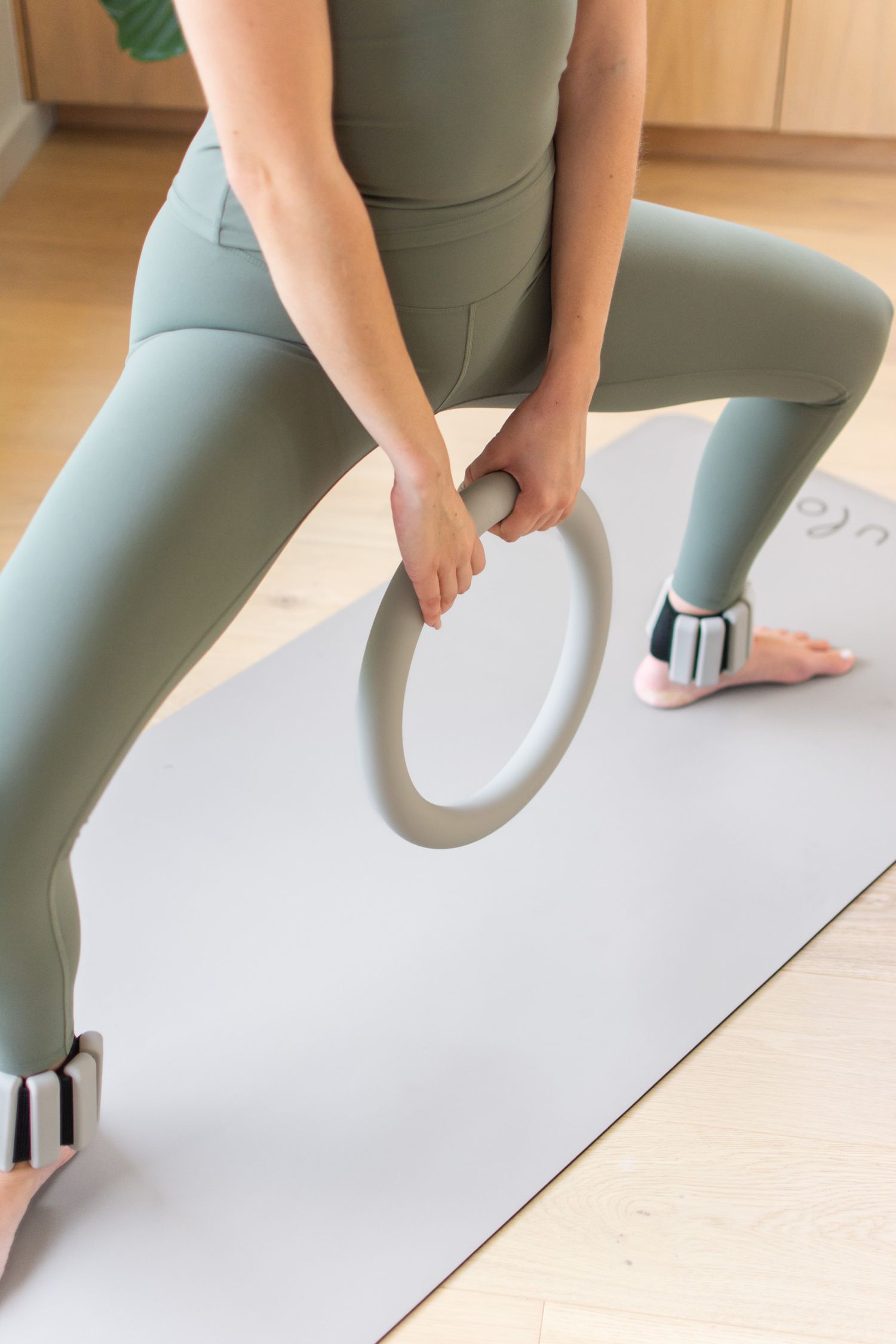 Model using Nulo resistance training equipment in Sage during a lifestyle product photography shoot.