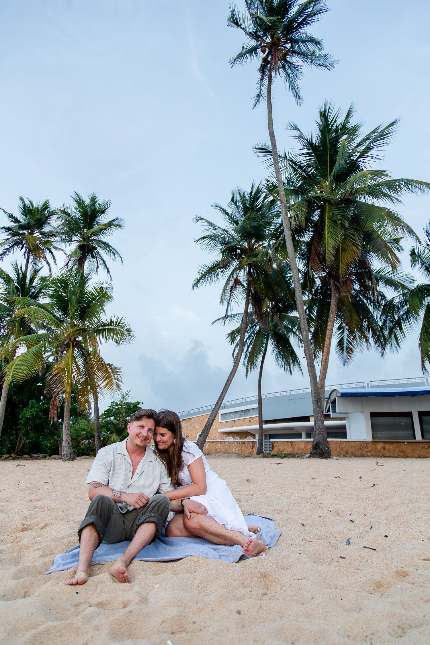 Couples portrait seated on the beach at Balneario del Escambrón in Old San Juan, Puerto Rico.