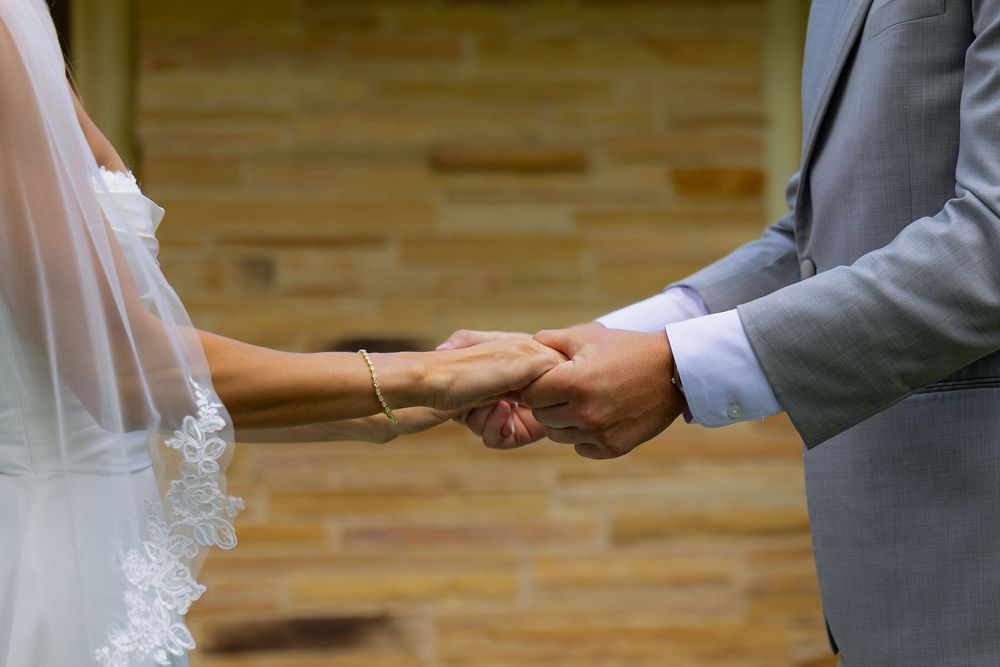 A bride and groom hold hands