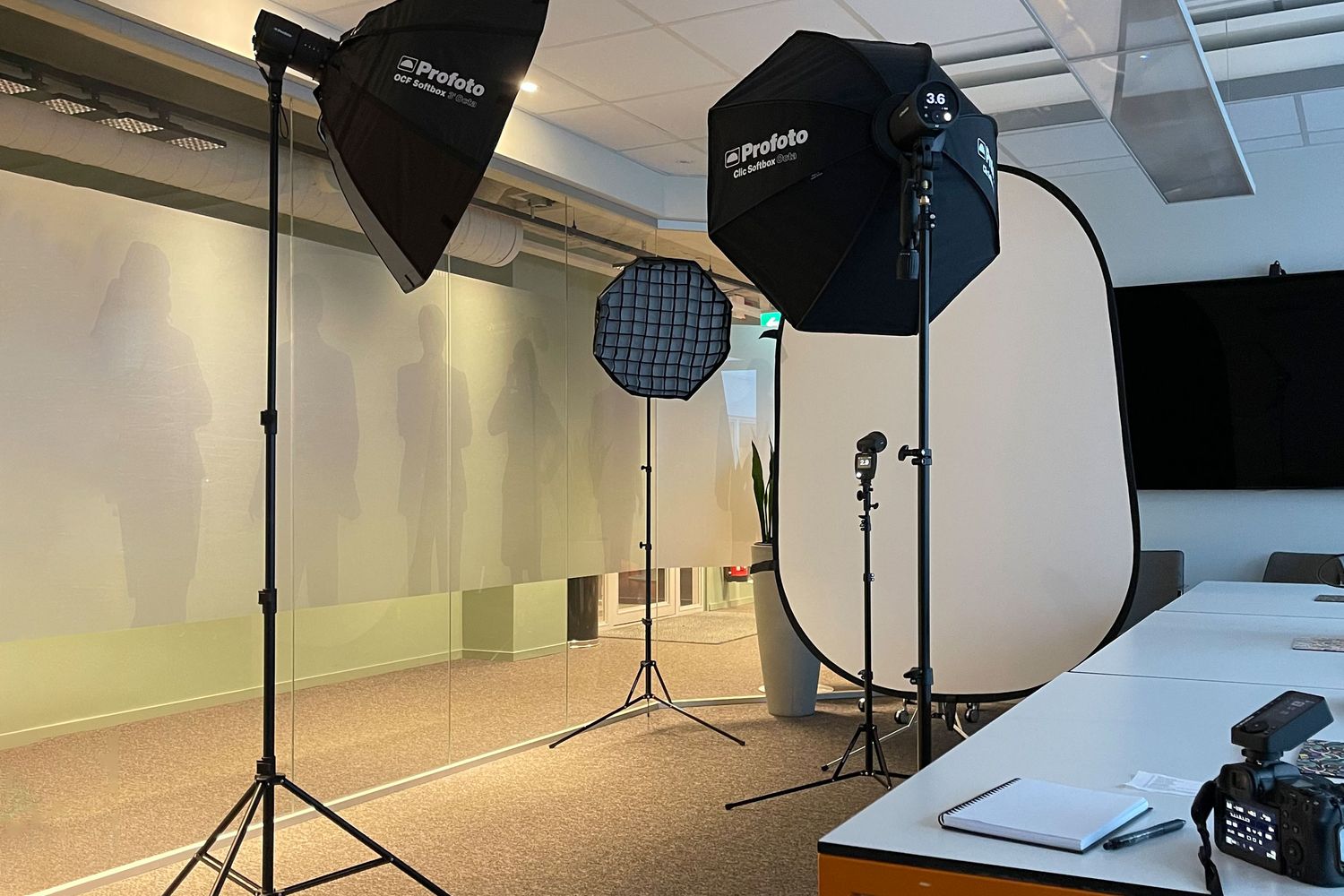 Professional photography studio setup with softboxes, light stands, and camera equipment in a clean white room.