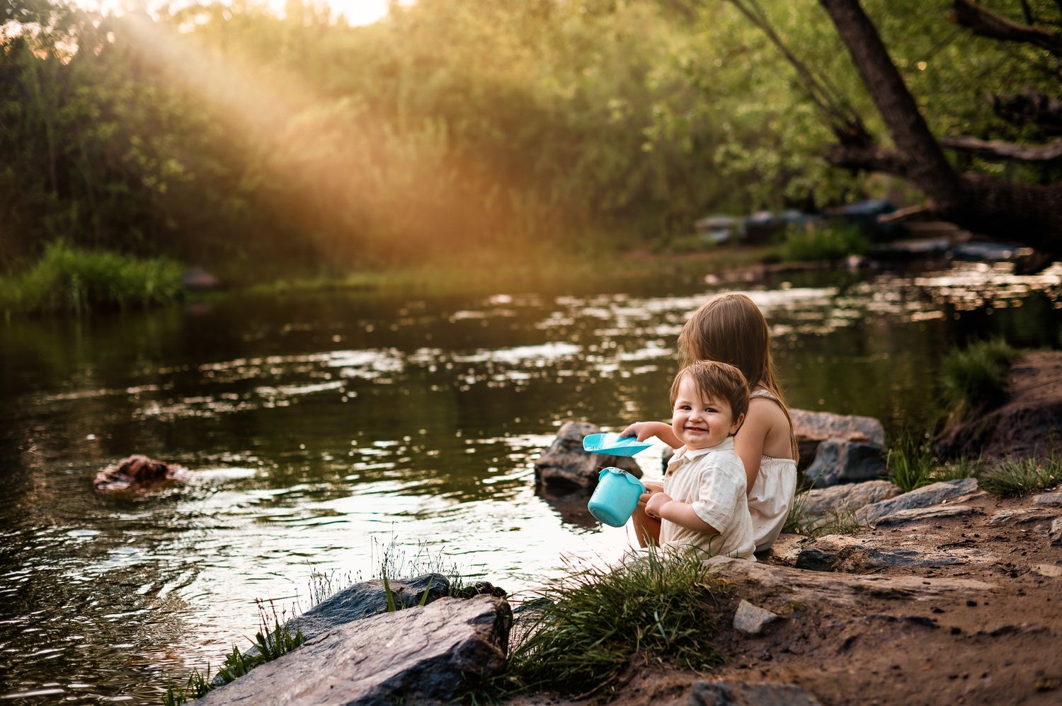 baby and big sister playing in a creek in conifer, co