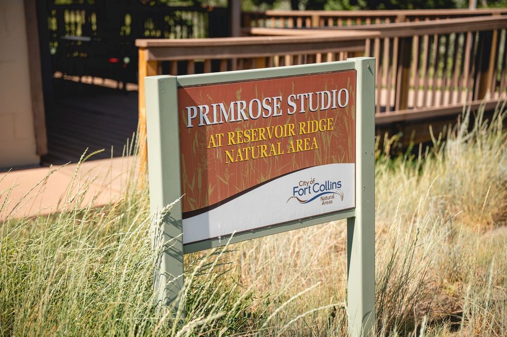 Sign for Primrose Studio at Reservoir Ridge Natural Area in Fort Collins, surrounded by native grasses.