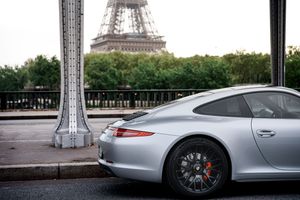 Silver Porsche 911 parked near the Eiffel Tower in Paris, France.