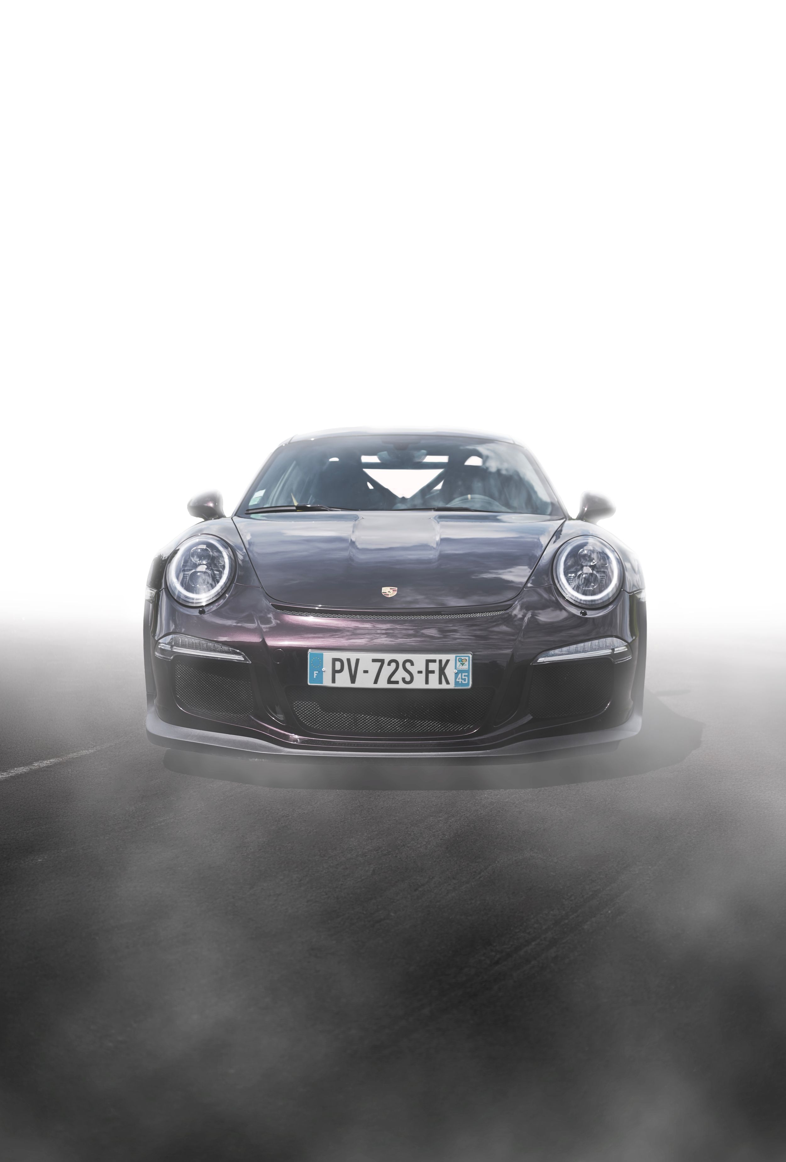 Black Porsche 911 GT3 RS front view with French license plate PV-72S-FK emerging from dramatic fog.