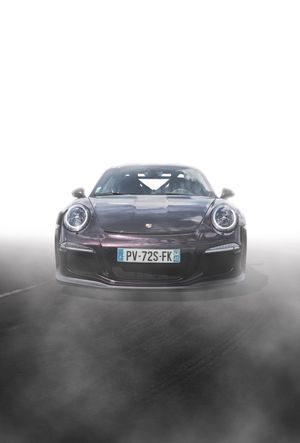 Black Porsche 911 GT3 RS front view with French license plate PV-72S-FK emerging from dramatic fog.