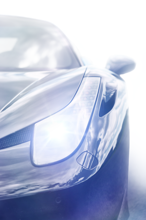 Overexposed artistic shot of a blue sports car front end with glowing headlight.