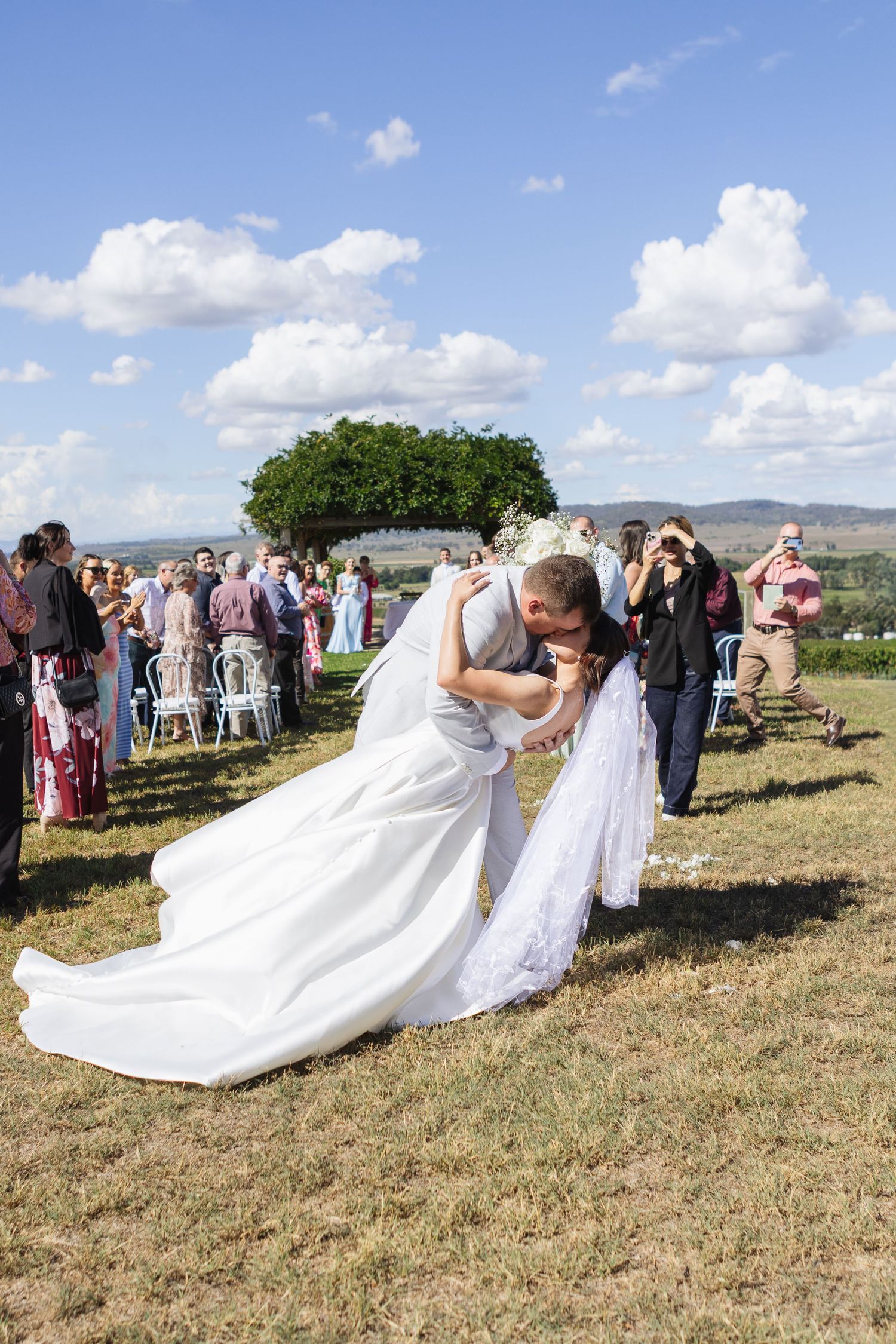 Bride and groom kissing in the aisle at Two Rivers Winery Wedding in Denman
